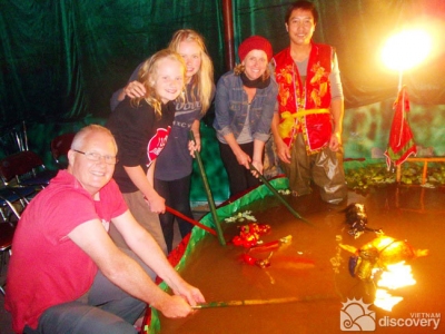 Tourists learn to control water puppets in a Hanoi city tour